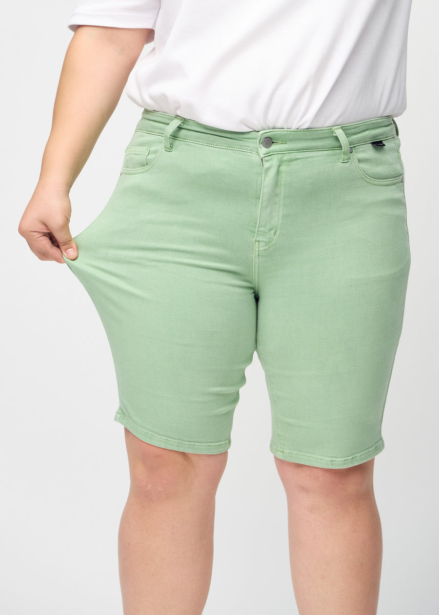 Plus-size-modellen strekker shortsene ved låret for å vise stretch.
