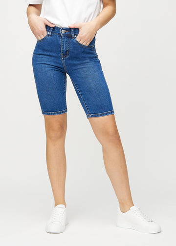 Mørk denim skinny middle shorts, modellnavn Oceans, som sitter tett på låret og slutter rett over kneet, sett forfra.