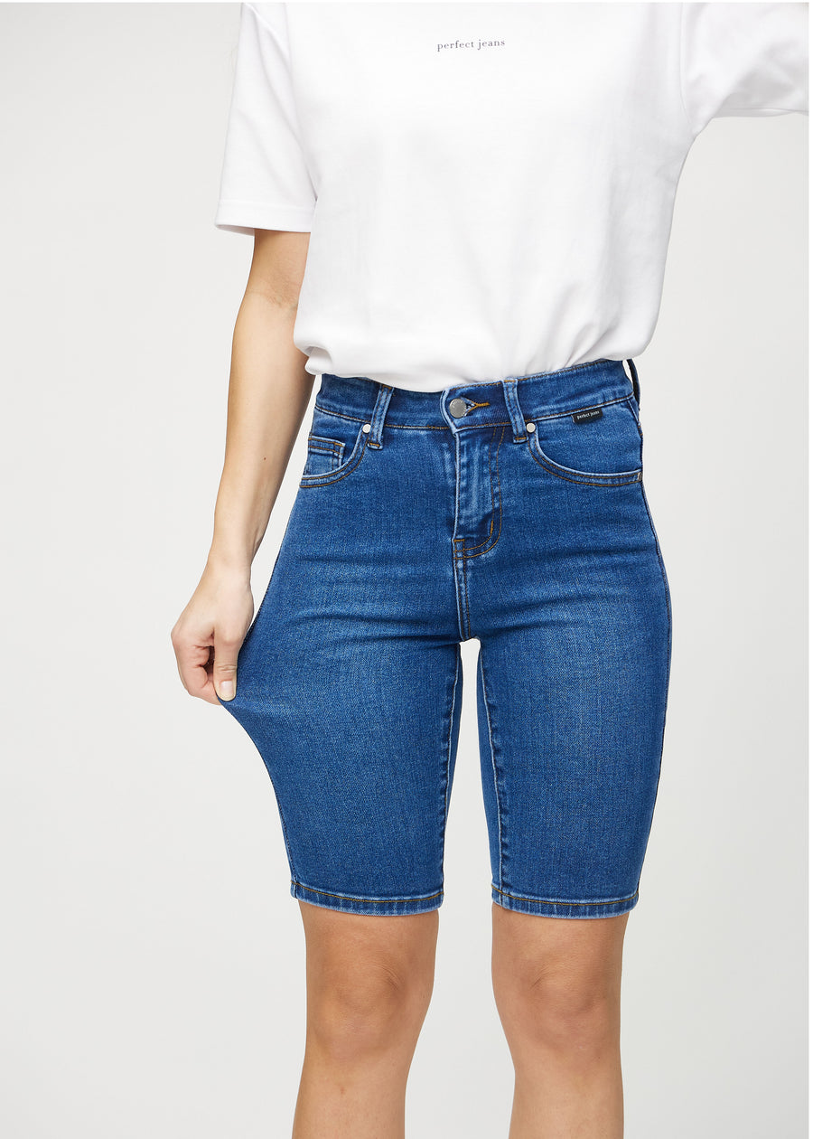 Modellen strekker shortsene ved låret for å vise stretch.