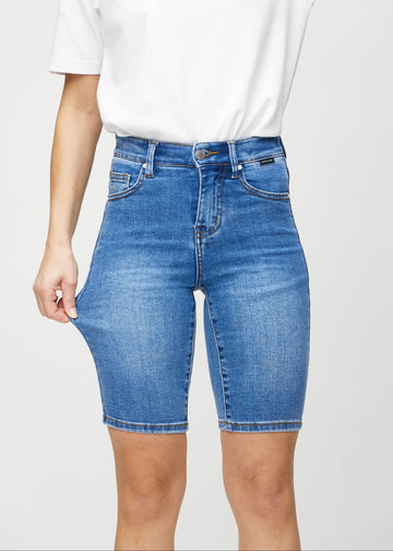 Modellen strekker shortsen ved låret for å vise stretch.