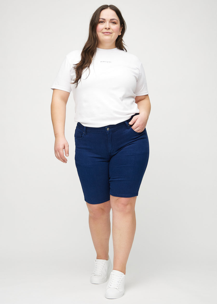 Fullt bilde av en plus-size-modell i mørkeblå skinny middle shorts.