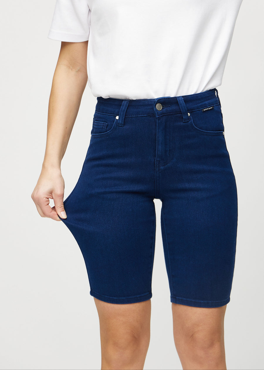 Modellen strekker shortsen ved låret for å vise stretch.