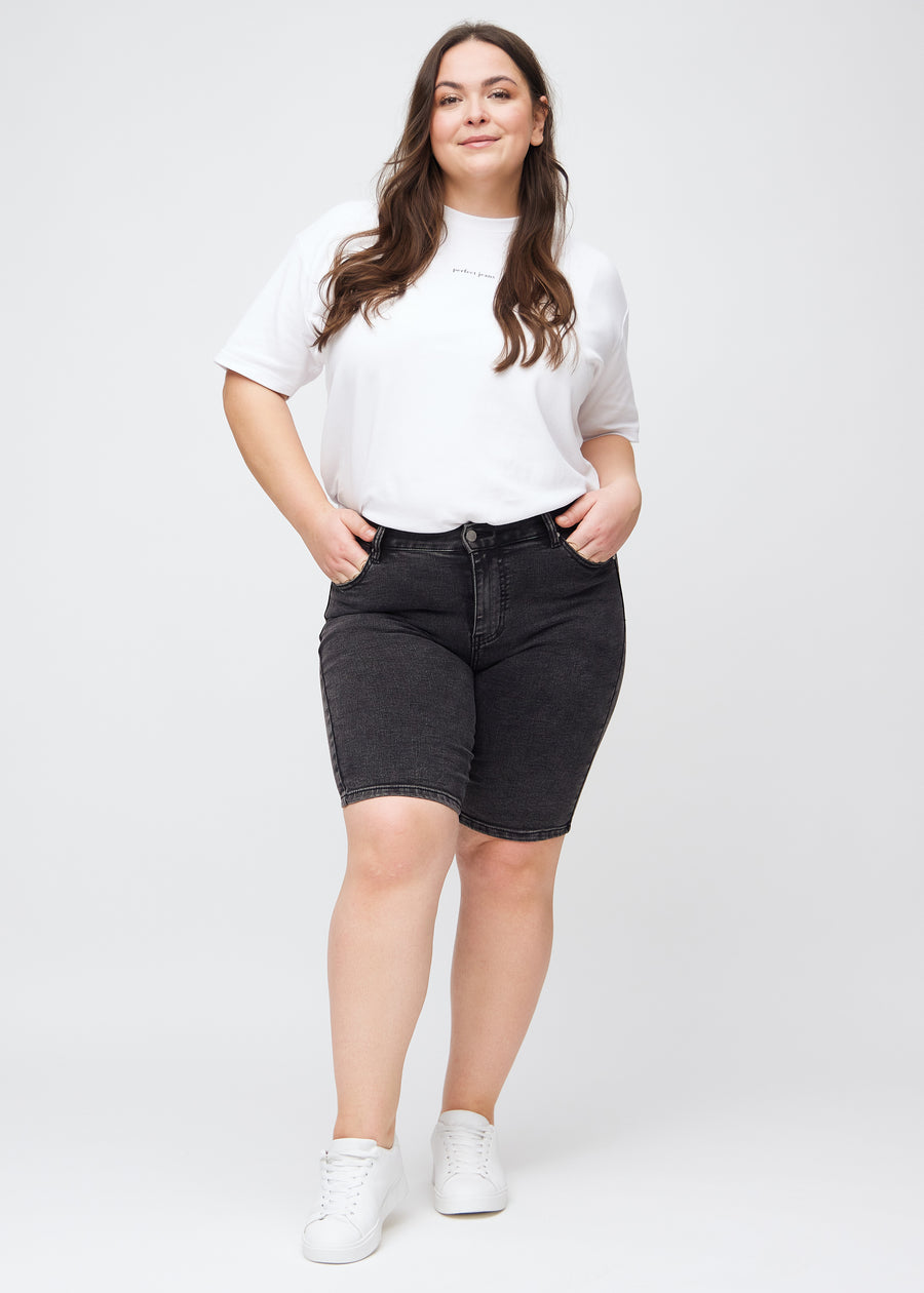 Fullt bilde av en plus-size modell i mørkegrå denim skinny middle shorts.