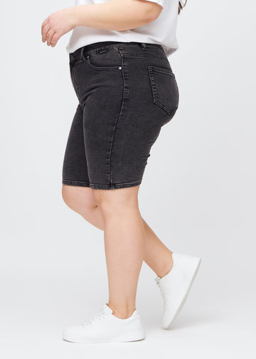 Mørkegrå denim skinny middle shorts sett fra siden på en plus-size modell.