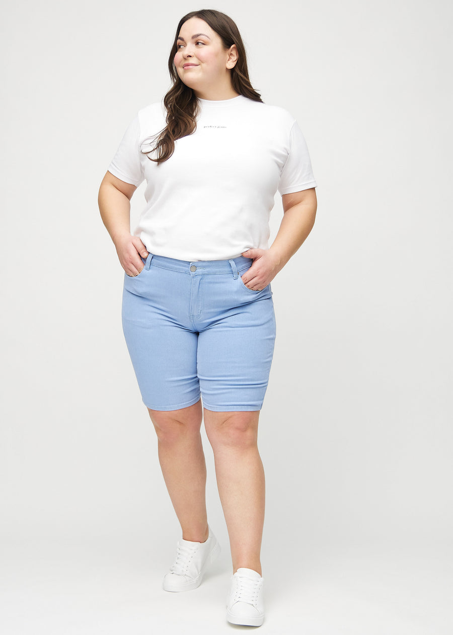 Fullt bilde av en plus-size-modell i lyseblå skinny middle shorts.