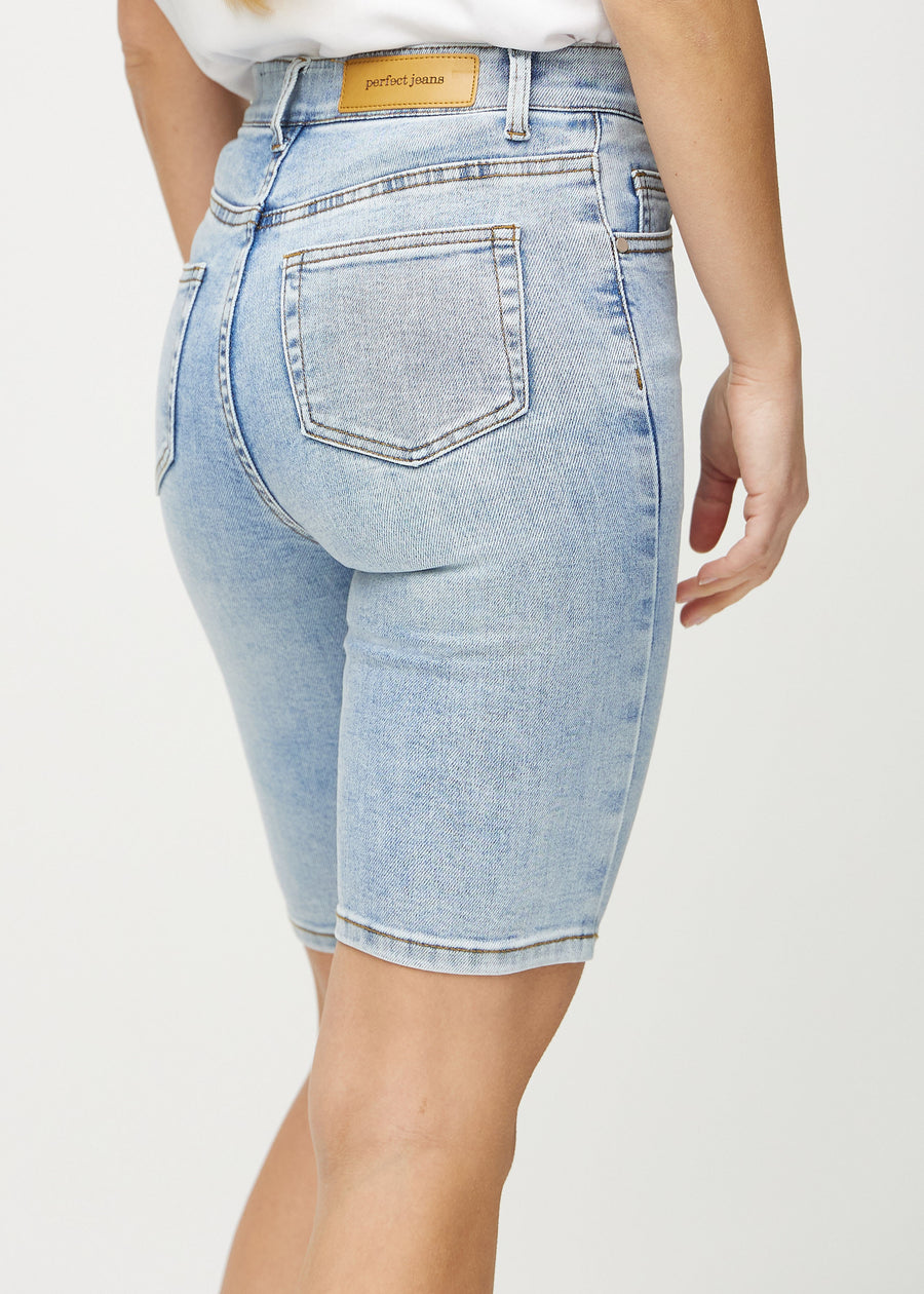 Lys denim skinny middle shorts sett bakfra på nært hold for å vise detaljer.
