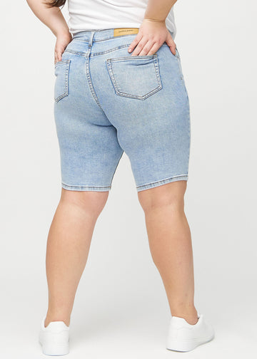 Lys denim skinny middle shorts sett bakfra på en plus-size-modell, slik at man kan se hele produktet.