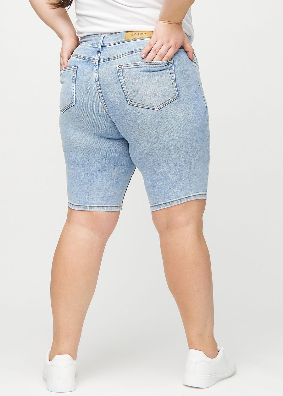 Lys denim skinny middle shorts sett bakfra på en plus-size-modell, slik at man kan se hele produktet.