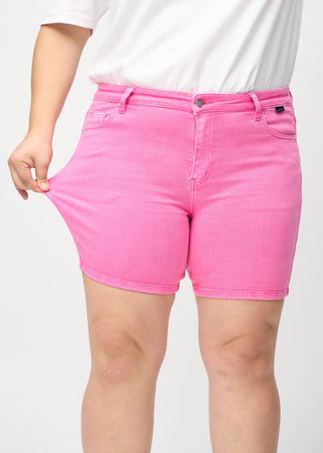 Plus-size-modellen strekker shortsen ved låret for å vise stretch.