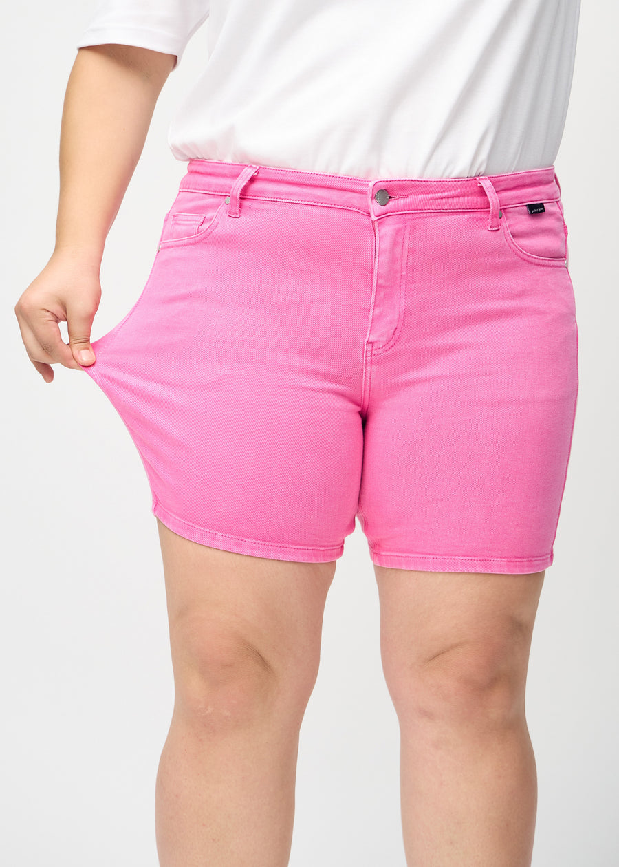 Plus-size-modellen strekker shortsen ved låret for å vise stretch.