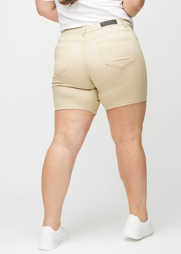 Beige skinny short shorts sett bakfra på en plus-size-modell, slik at man kan se hele produktet.