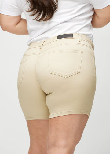 Beige skinny short shorts sett bakfra på nært hold på en plus-size-modell for å vise detaljer.