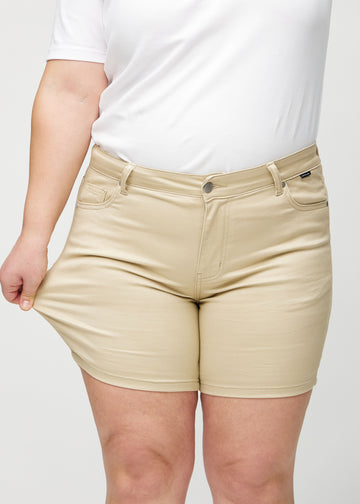 Plus-size-modellen strekker shortsen ved låret for å vise stretch.
