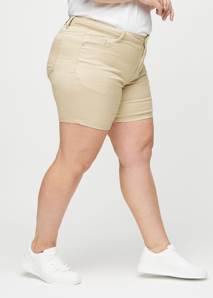 Beige skinny short shorts sett fra siden på en plus-size-modell.