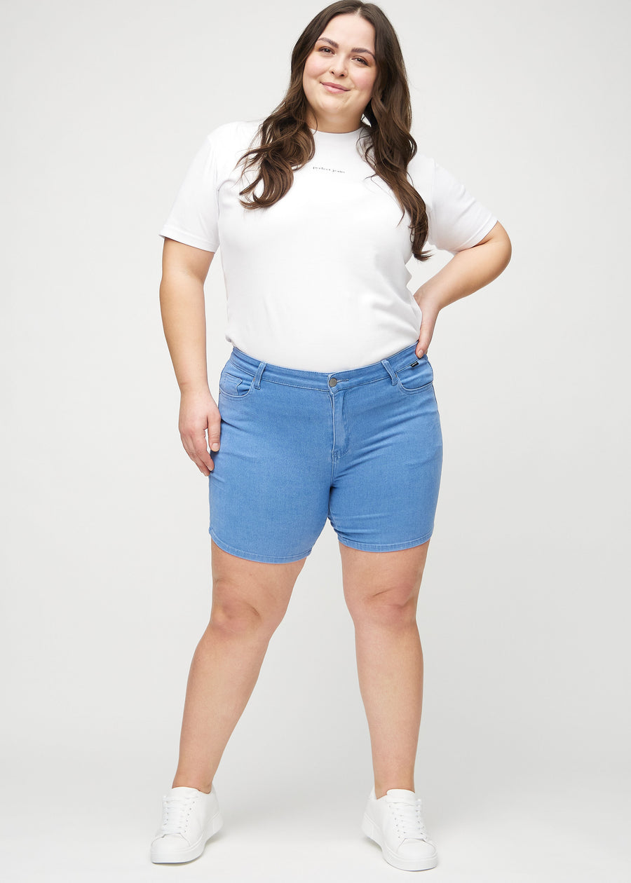 Fullt bilde av en plus-size-modell i blå skinny short shorts.