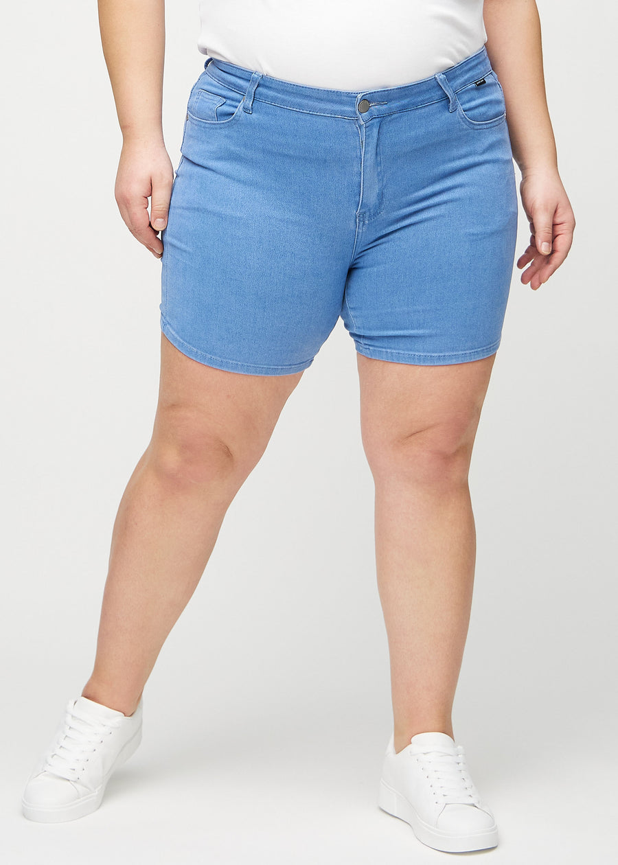 Blå skinny short shorts, modellnavn Geraniums, som sitter tett og slutter midt på låret på en plus-size-modell, sett forfra.