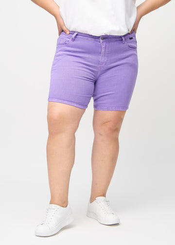 Lilla skinny short shorts, modellnavn Lavenders, som sitter tett inntil og slutter midt på låret på en plus-size modell, sett forfra.