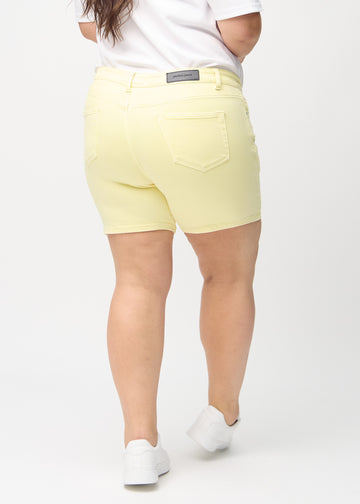 Lysegule skinny short shorts sett bakfra på en plus-size-modell, så man kan se hele produktet.