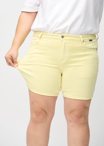 Plus-size-modellen strekker shortsene ved låret for å vise stretch.