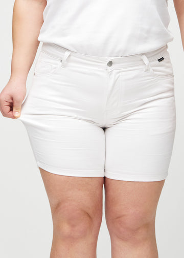 Plus-size-modellen strekker shortsen ved låret for å vise stretch.