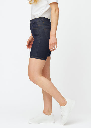 Dyp mørkeblå denimshorts til dame i fargen Midnights med skinny passform sett fra siden på modell.
