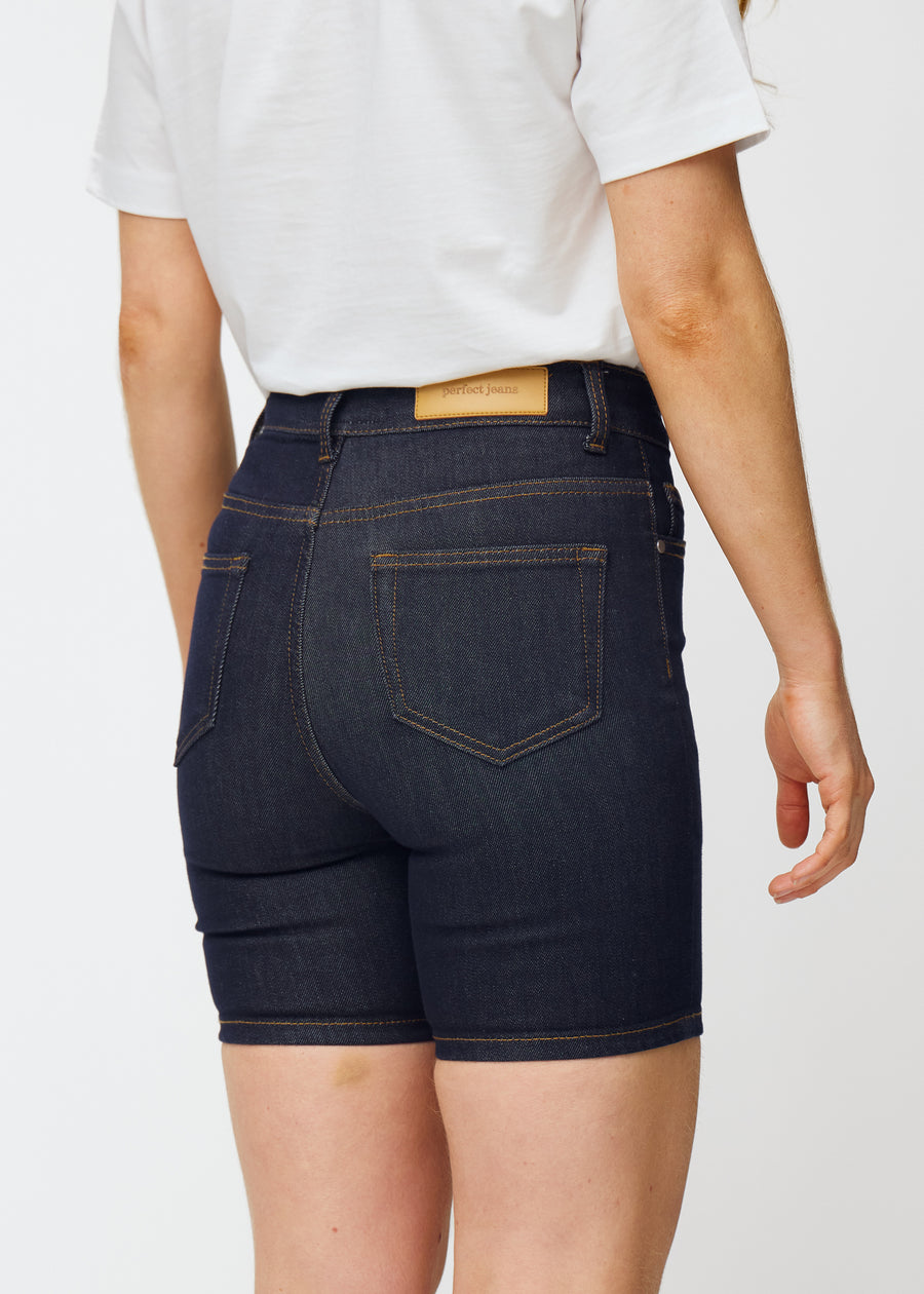 Dyp mørkeblå denimshorts til dame i fargen Midnights sett bakfra i nærbilde for å vise passform og detaljer.