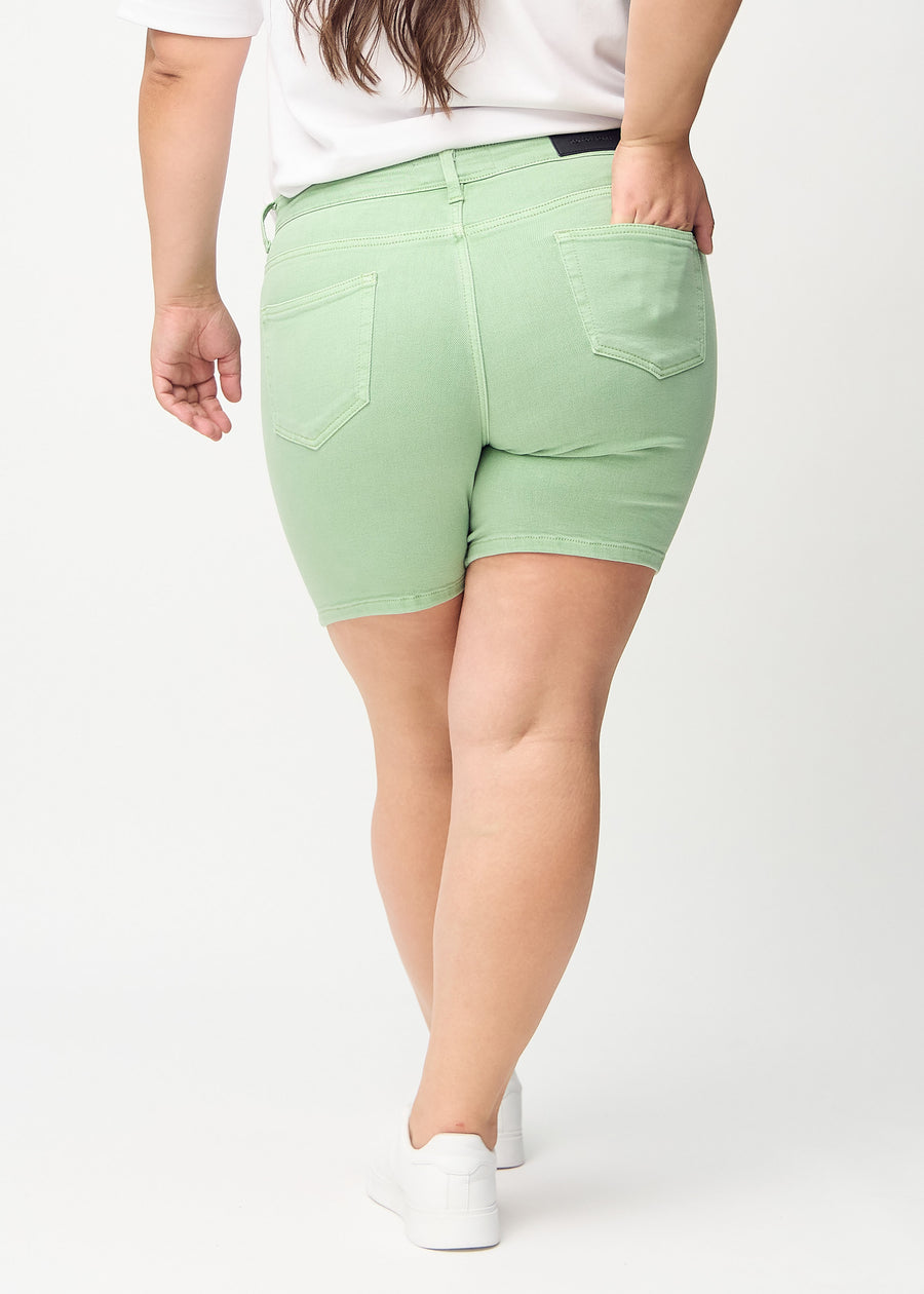 Lysegrønne skinny short shorts sett bakfra på en plus-size-modell, så man kan se hele produktet.