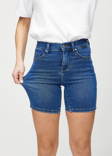 Modellen strekker shortsene ved låret for å vise stretch.
