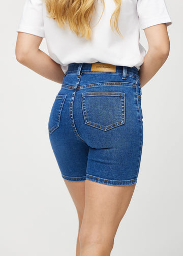 Mørk denim skinny short shorts sett bakfra på nært hold for å vise detaljer.