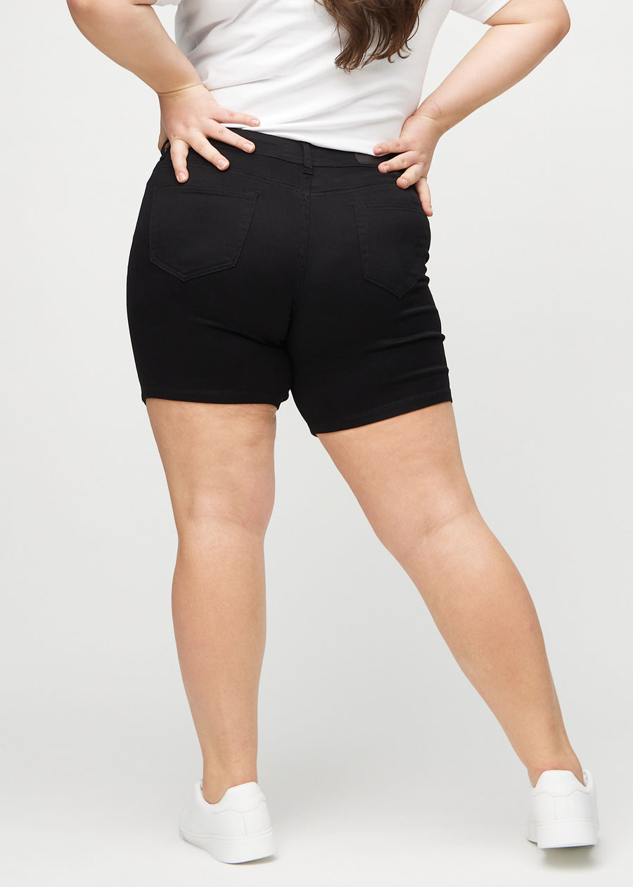 Svarte skinny short shorts sett bakfra på en plus-size-modell, slik at man kan se hele produktet.