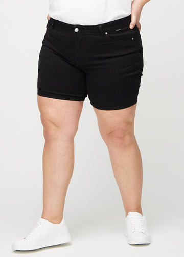 Svarte skinny short shorts, modellnavn Ravens, som sitter tett og slutter midt på låret på en plus-size-modell, sett forfra.