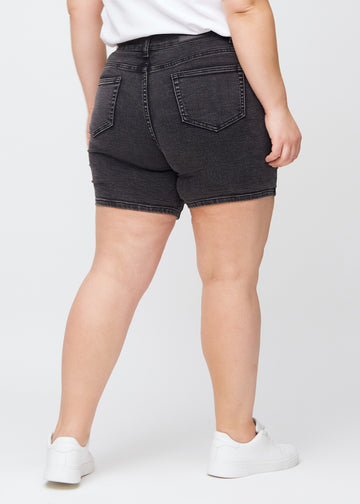 Mørkegrå denim skinny short shorts sett bakfra på en plus-size-modell, så man kan se hele produktet.