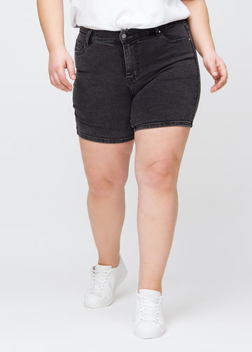 Mørkegrå denim skinny short shorts, modellnavn Shadows, som sitter tett og slutter midt på låret på en plus-size-modell, sett forfra.