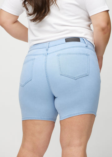  Lyseblå skinny short shorts sett bakfra på nært hold på en plus-size-modell for å vise detaljer.