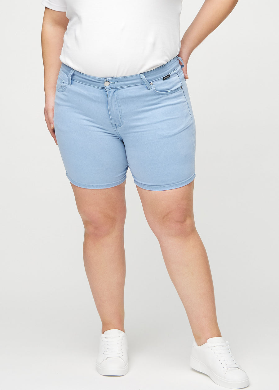 Lyseblå skinny short shorts, modellnavn Skies, som sitter tett, og slutter midt på låret på en plus-size-modell, sett forfra.