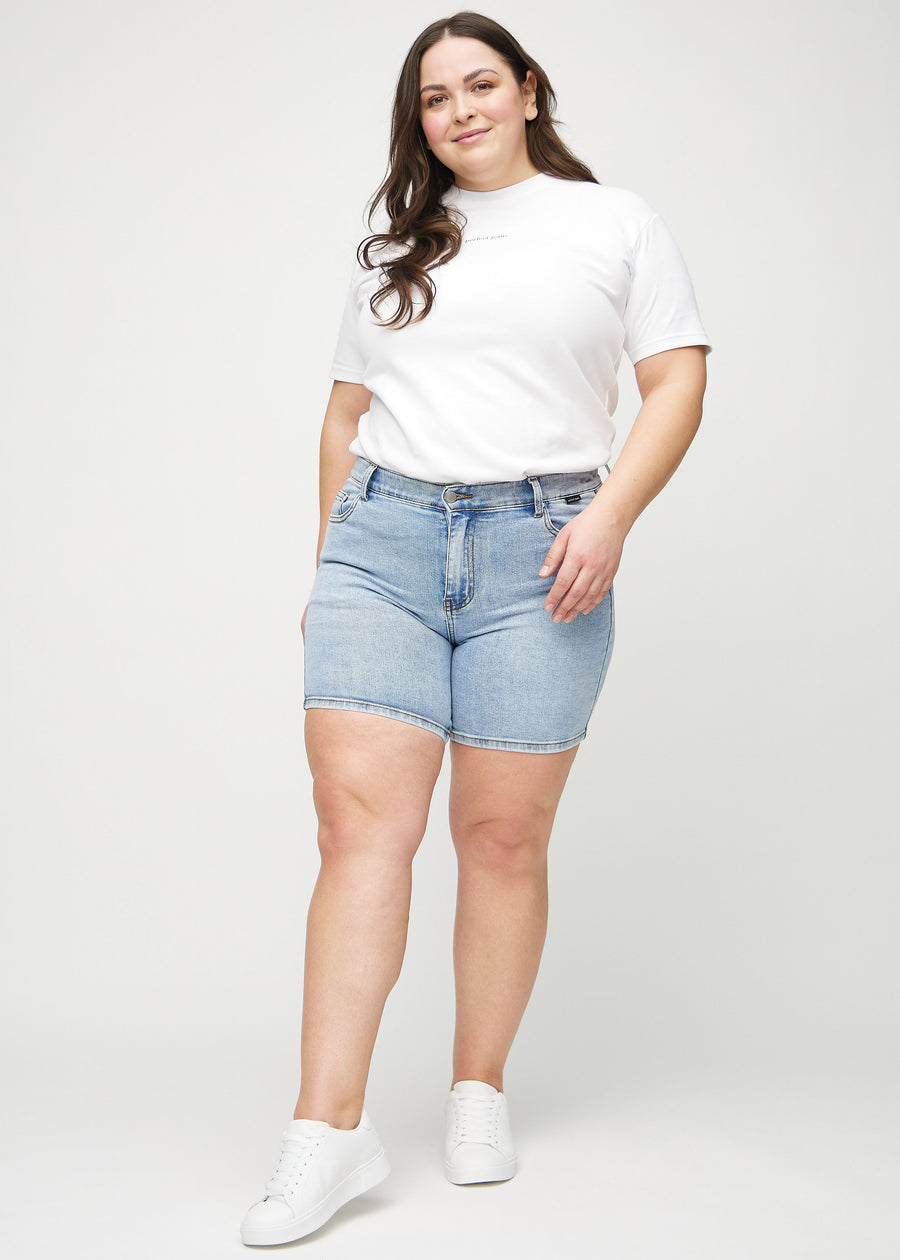 Fullt bilde av en plus-size modell i lys denim skinny short shorts.