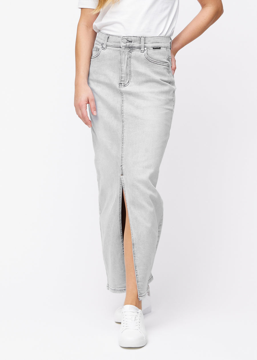 Langt lysegrått denimskjørt til kvinner i fargen Ashes. Sett forfra på en modell, med rett fall fra hoftene og en splitt foran som starter rett under kneet.