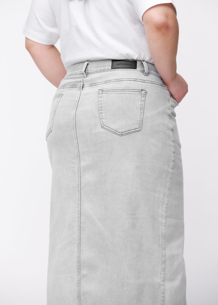 Langt lysegrått denimskjørt til kvinner i fargen Ashes. Nærbilde bakfra på en plus size-modell som viser passform og detaljer.