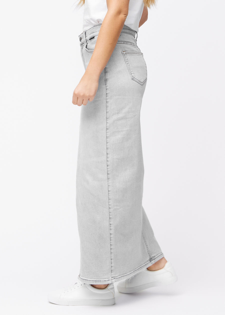 Langt lysegrått denimskjørt til kvinner i fargen Ashes. Sett fra siden på en modell, med synlig splitt foran.