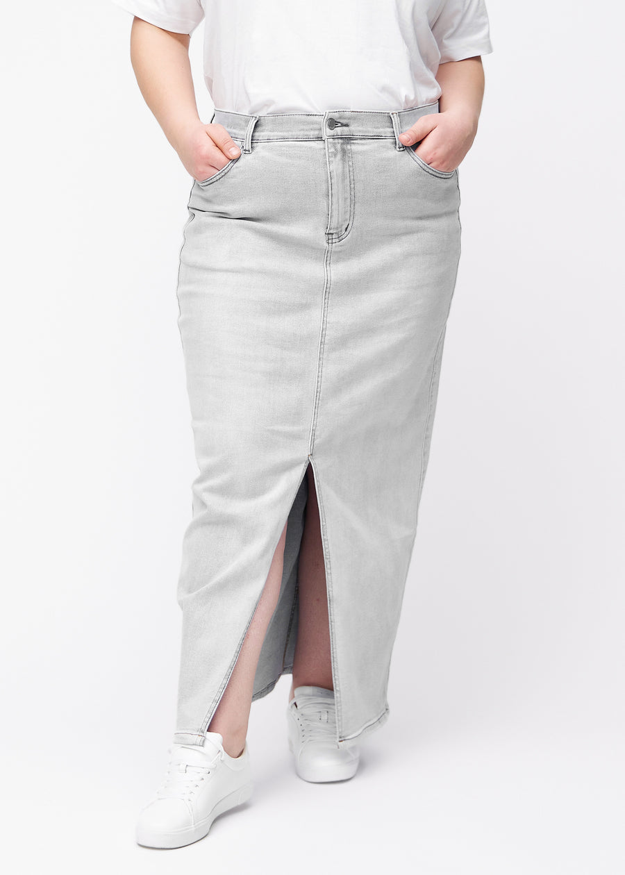 Langt lysegrått denimskjørt til kvinner i fargen Ashes. Sett forfra på en plus size-modell, med rett fall fra hoftene og en splitt foran som starter rett under kneet.