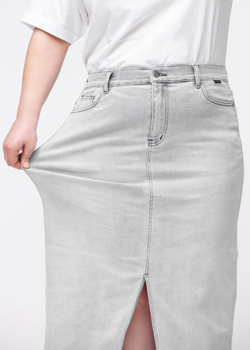 Langt lysegrått denimskjørt til kvinner i fargen Ashes. En plus size-modell strekker stoffet ved hoften for å vise stretchen.