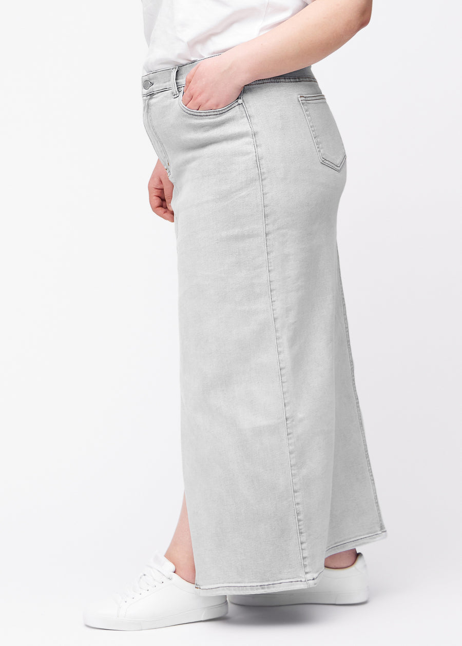 Langt lysegrått denimskjørt til kvinner i fargen Ashes. Sett fra siden på en plus size-modell, med synlig splitt foran.