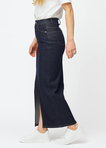 Langt dyp mørkeblått denimskjørt til dame i fargen Midnights sett fra siden på modell, med synlig splitt foran.