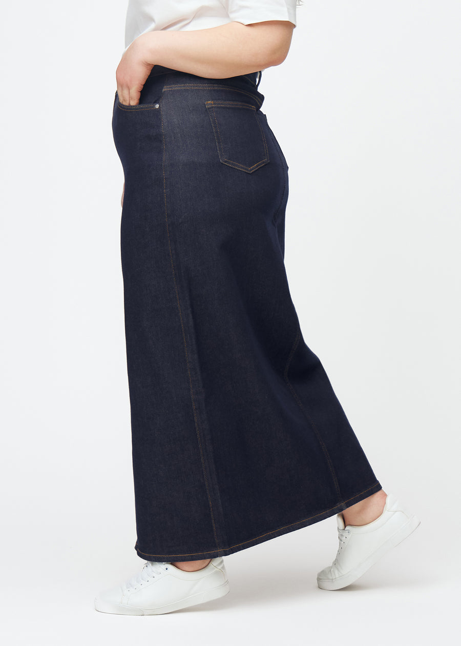 Langt dyp mørkeblått denimskjørt til dame i fargen Midnights sett fra siden på plus-size modell, med synlig splitt foran.