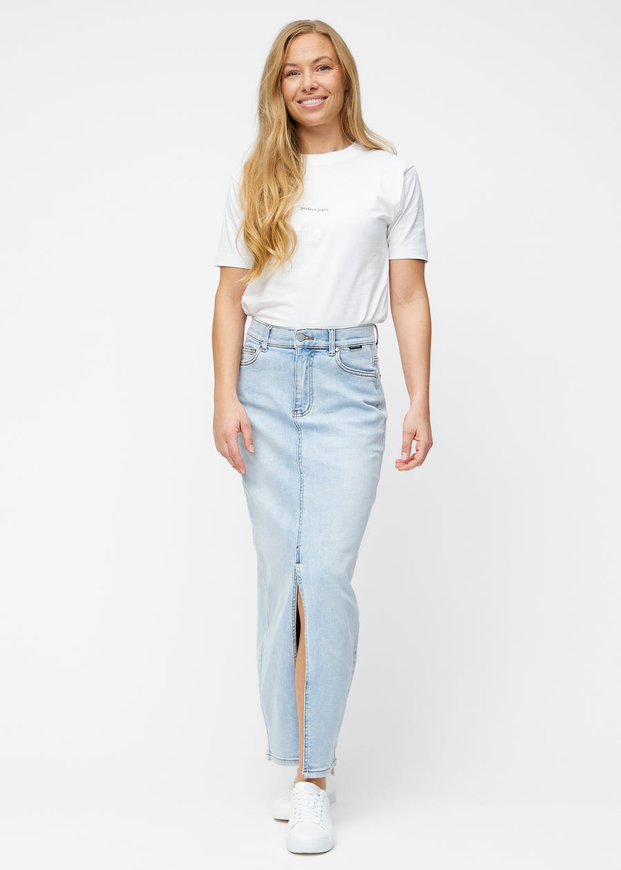 Fuldt billede af model i lang, lyseblå denimnederdel i farven Waves med regulær pasform og slids foran.