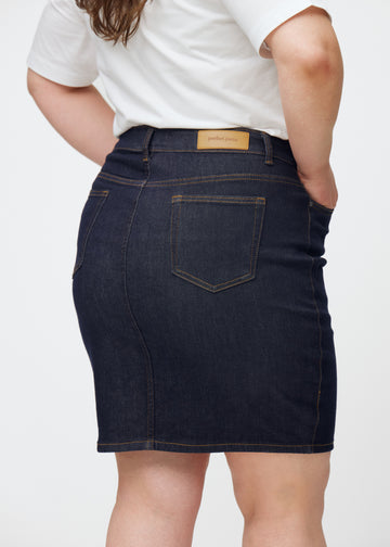 Dyp mørkeblå denimskjørt til dame i fargen Midnights sett bakfra i nærbilde på plus-size modell.