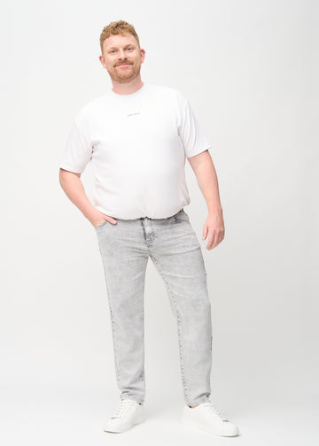 Fullt bilde av en plus-size-modell i lys grå denim regular jeans.