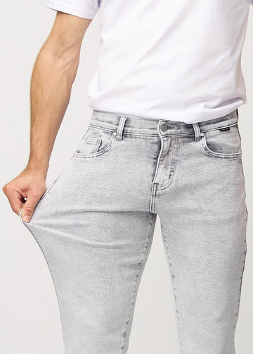 Modellen strekker jeansene ved låret for å vise stretch.