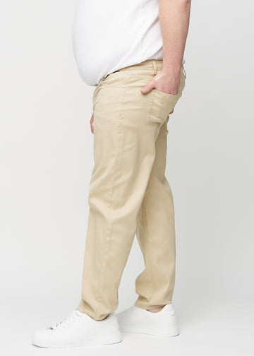 Beige regular jeans sett fra siden på en plus-size-modell.