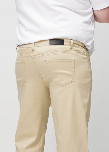 Beige regular jeans sett bakfra på nært hold på en plus-size-modell for å vise detaljer.